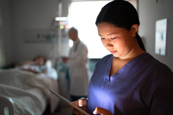 millenial nurse using tablet in hospital room