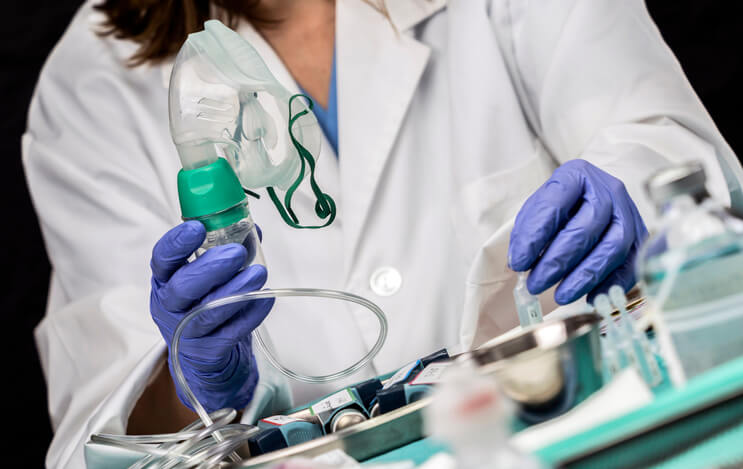 woman in lab coat working with respiratory equipment