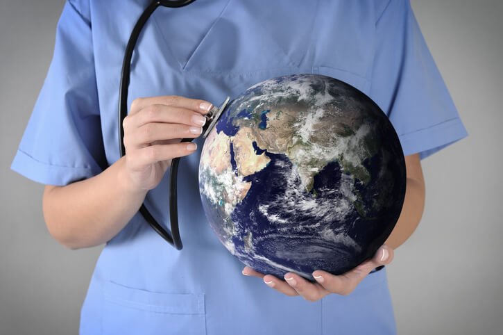 global health depicted as nurse holding stethoscope to a model of Earth