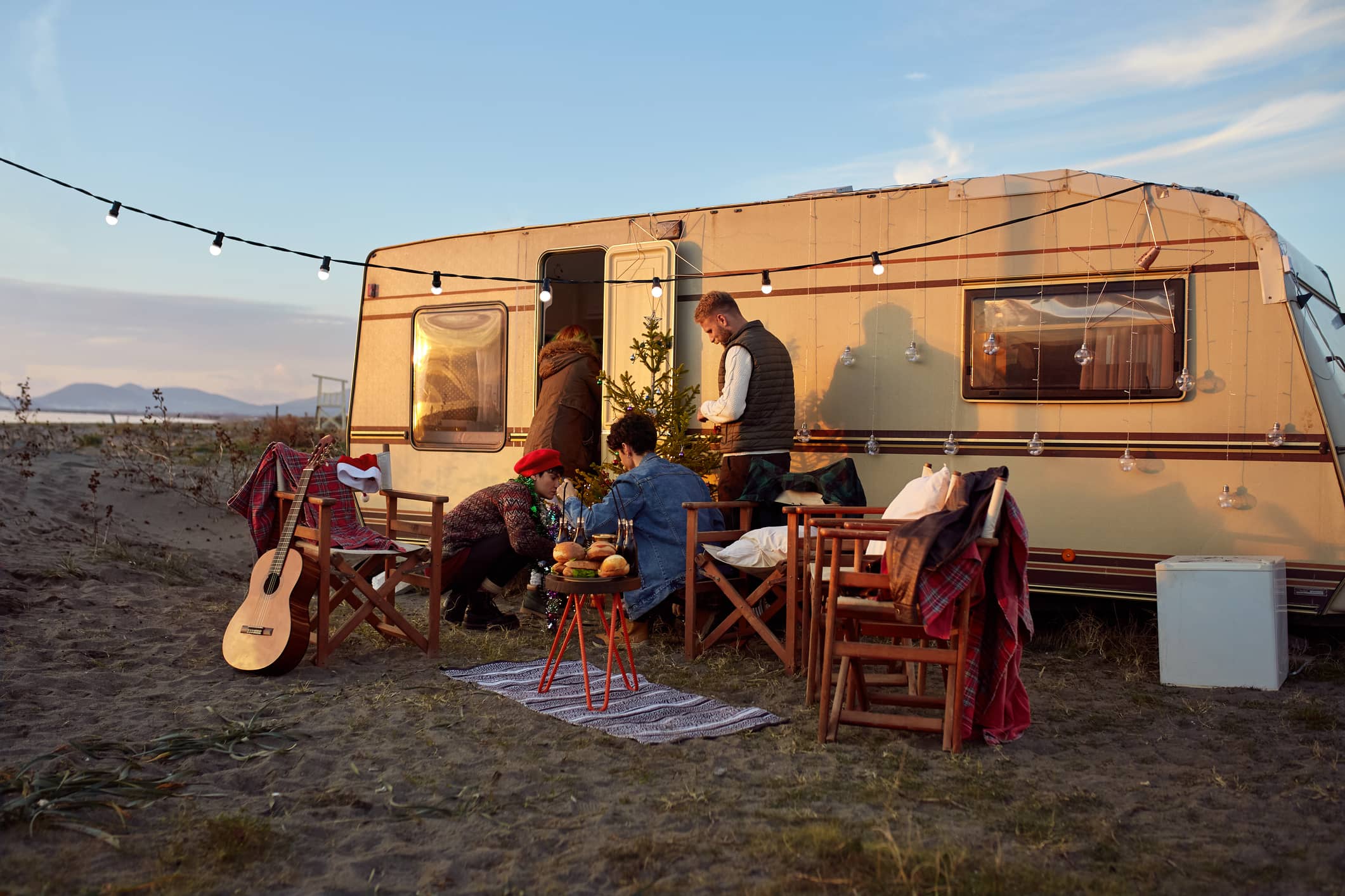 Group of friends outside an RV trailer in the wilderness