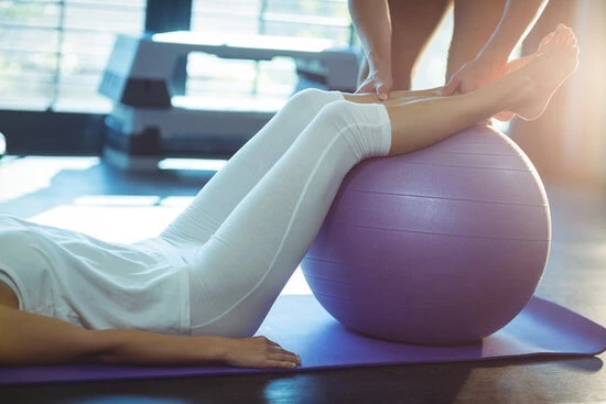 Woman using exercise ball in clinical environment