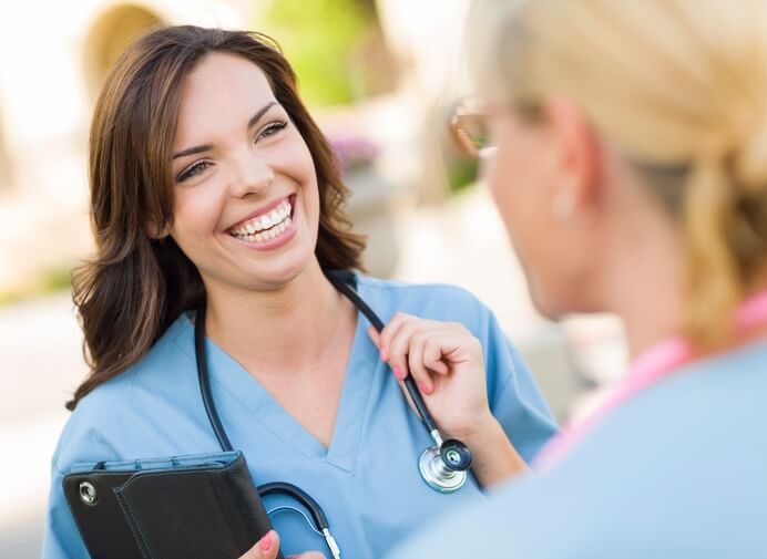 smiling contract nurse talking to another