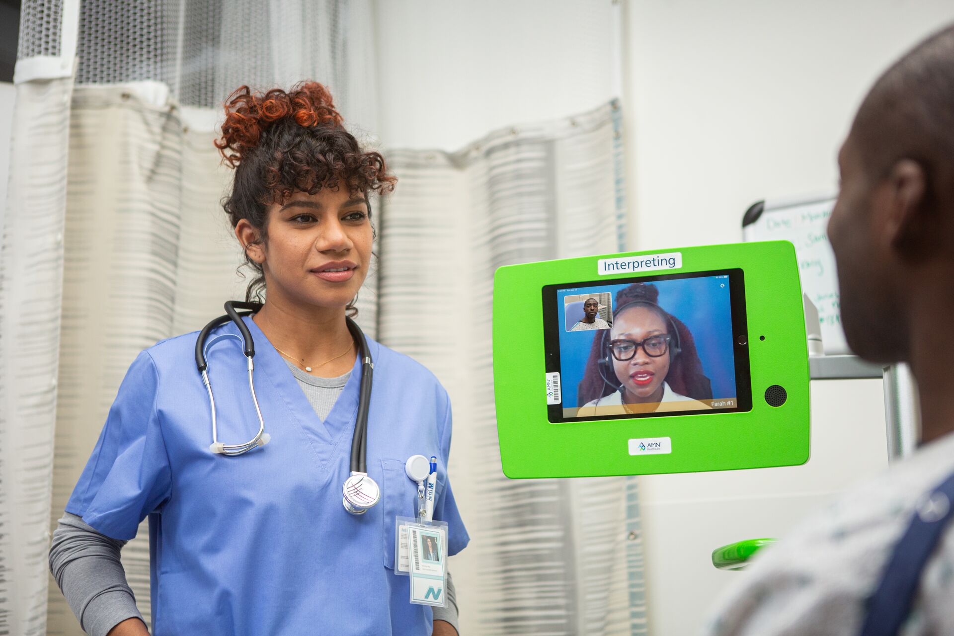 Clinician with patient and a remote interpreter helping with communications Clinician with patient and a remote interpreter helping with communications
