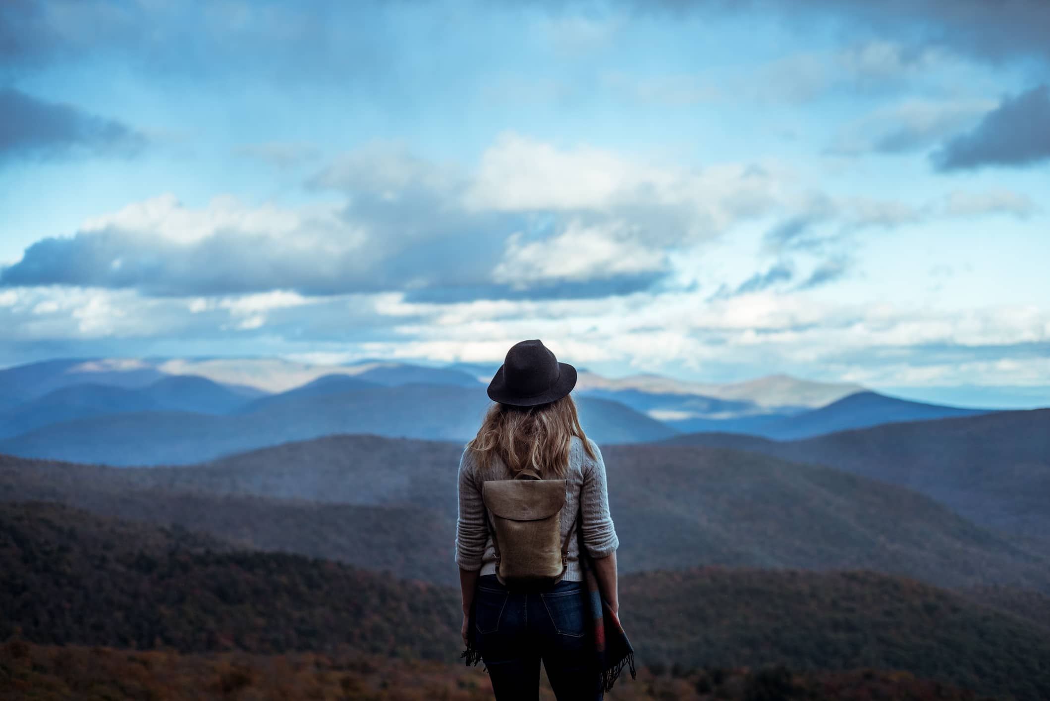 Woman staring out across a beautiful distant mountain scape
