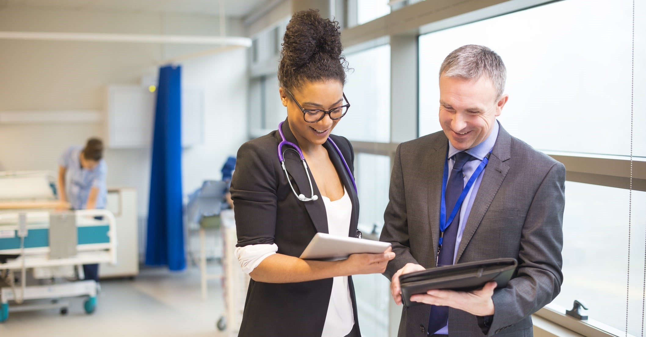 two medical professionals discussing findings on tablet
