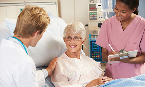 Elderly female patient with clinicians in hospital setting Elderly female patient with clinicians in hospital setting