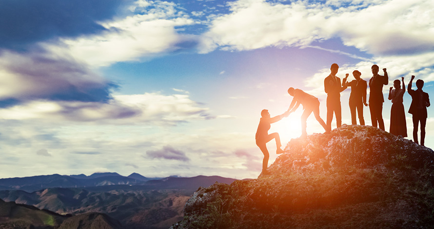 Group of hikers reaching the summit of a mountain Group of hikers reaching the summit of a mountain