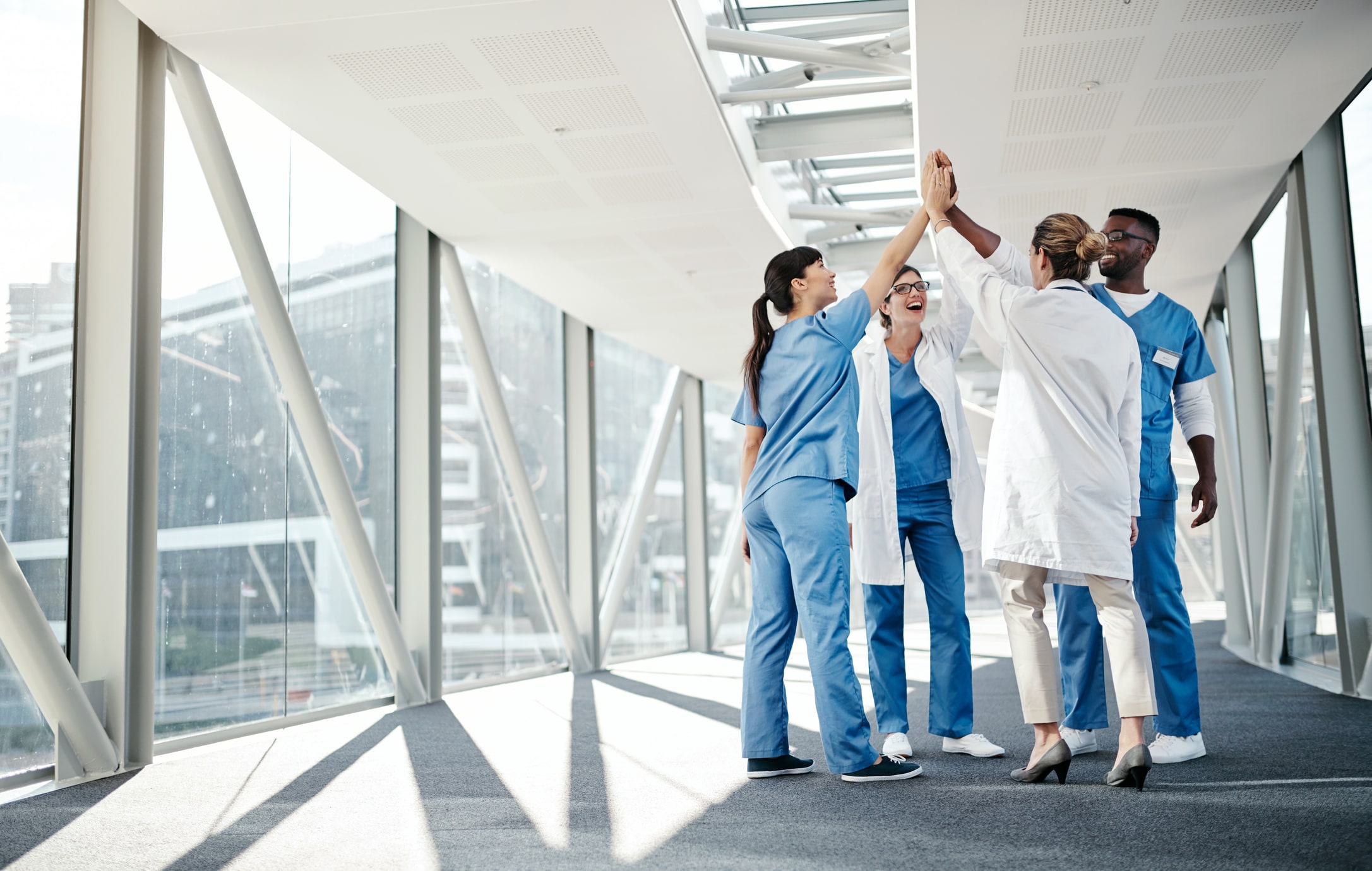 group of nurses and doctors in hospitals high-fiving group of nurses and doctors in hospitals high-fiving
