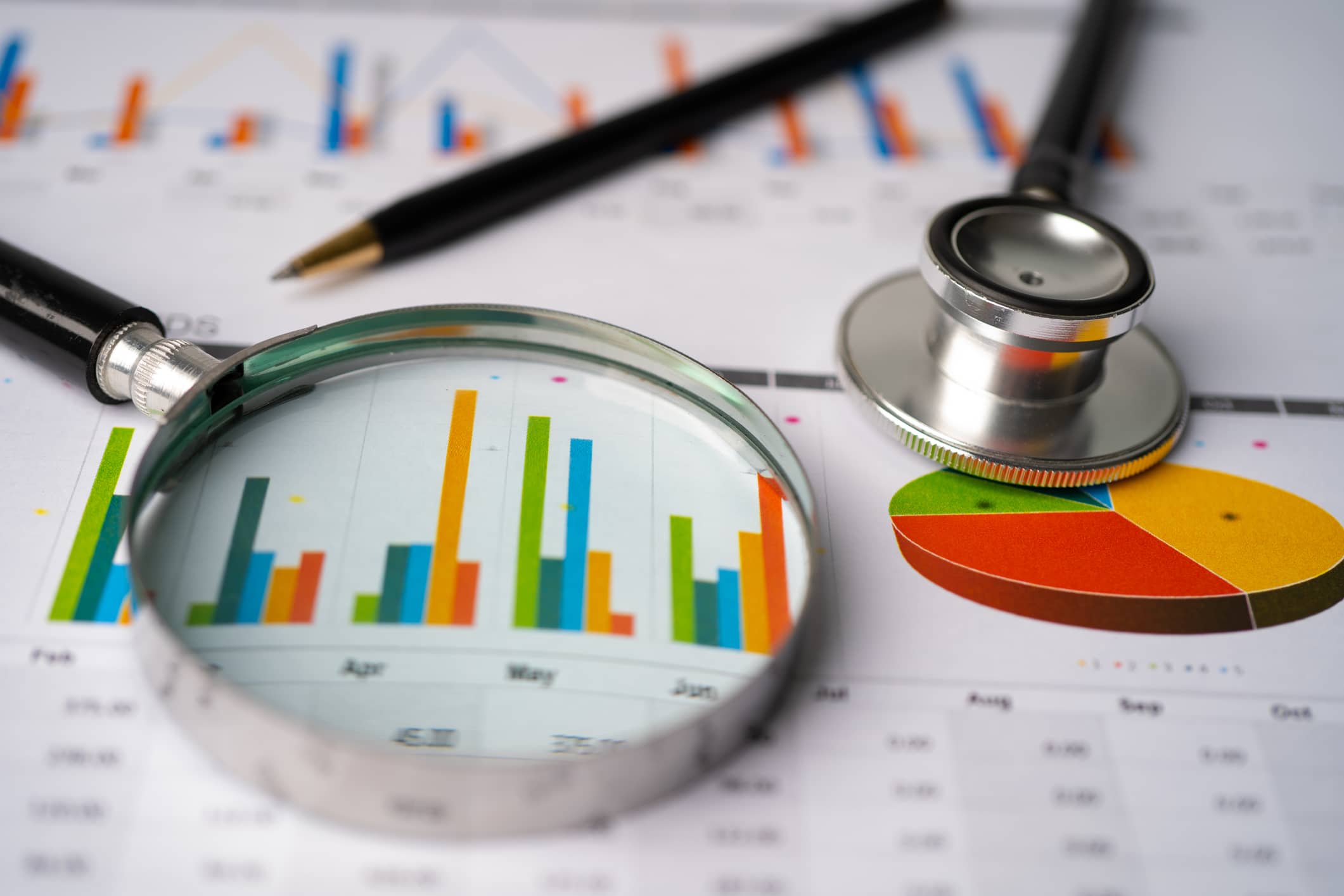 Stethoscope and magnifying glass laying on report Stethoscope and magnifying glass laying on report