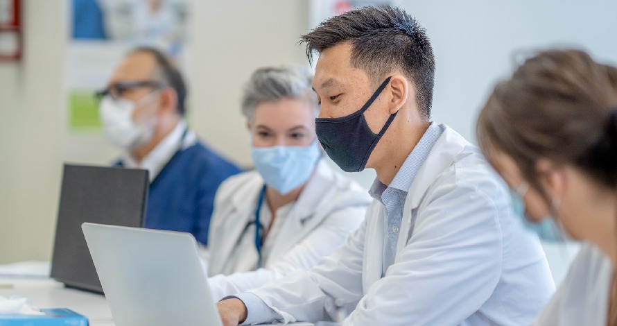 nurses in conference meeting looking at laptop