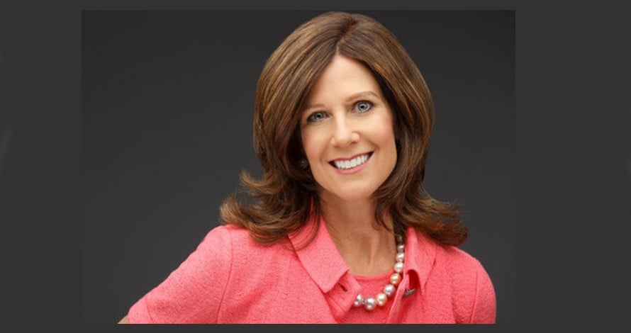 susan salka smilling in a salmon colored business blouse