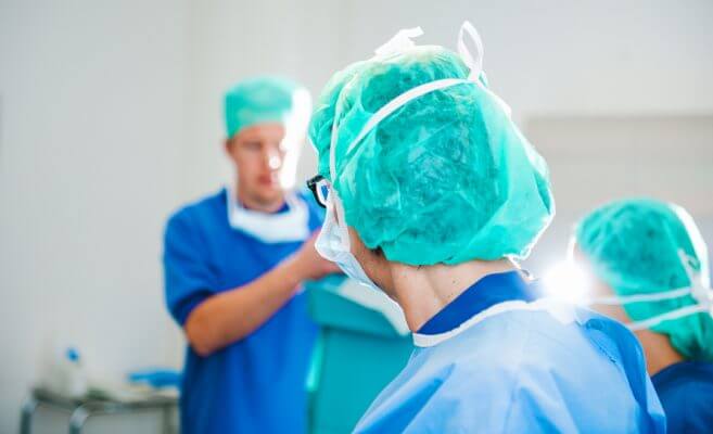 medical professionals in surgical scrubs and cap