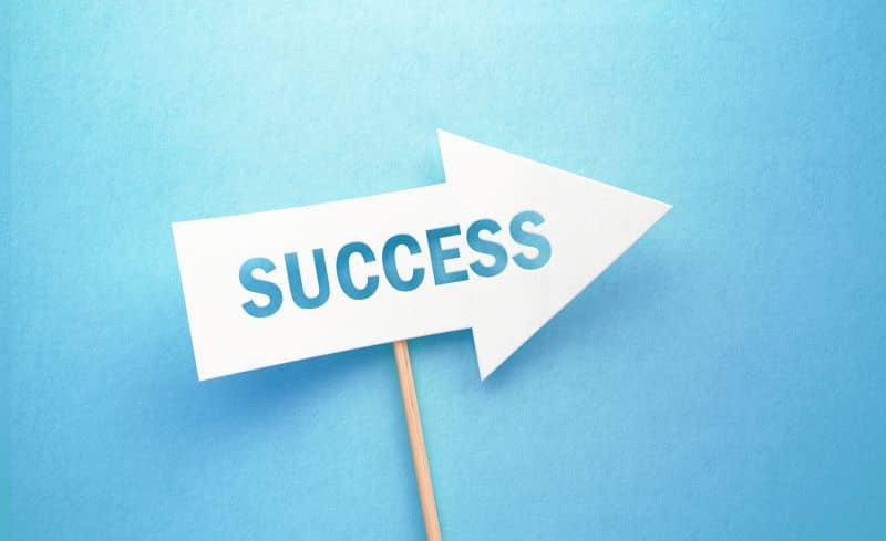 Success Written White Arrow On Blue Background