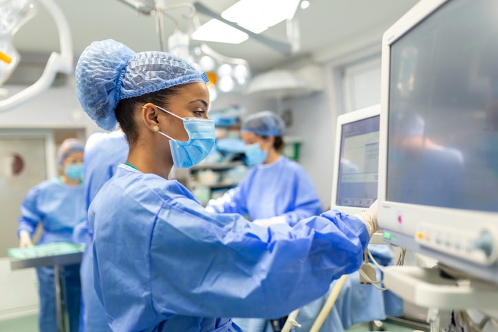 a CRNA looking at a monitor in a hosptial setting