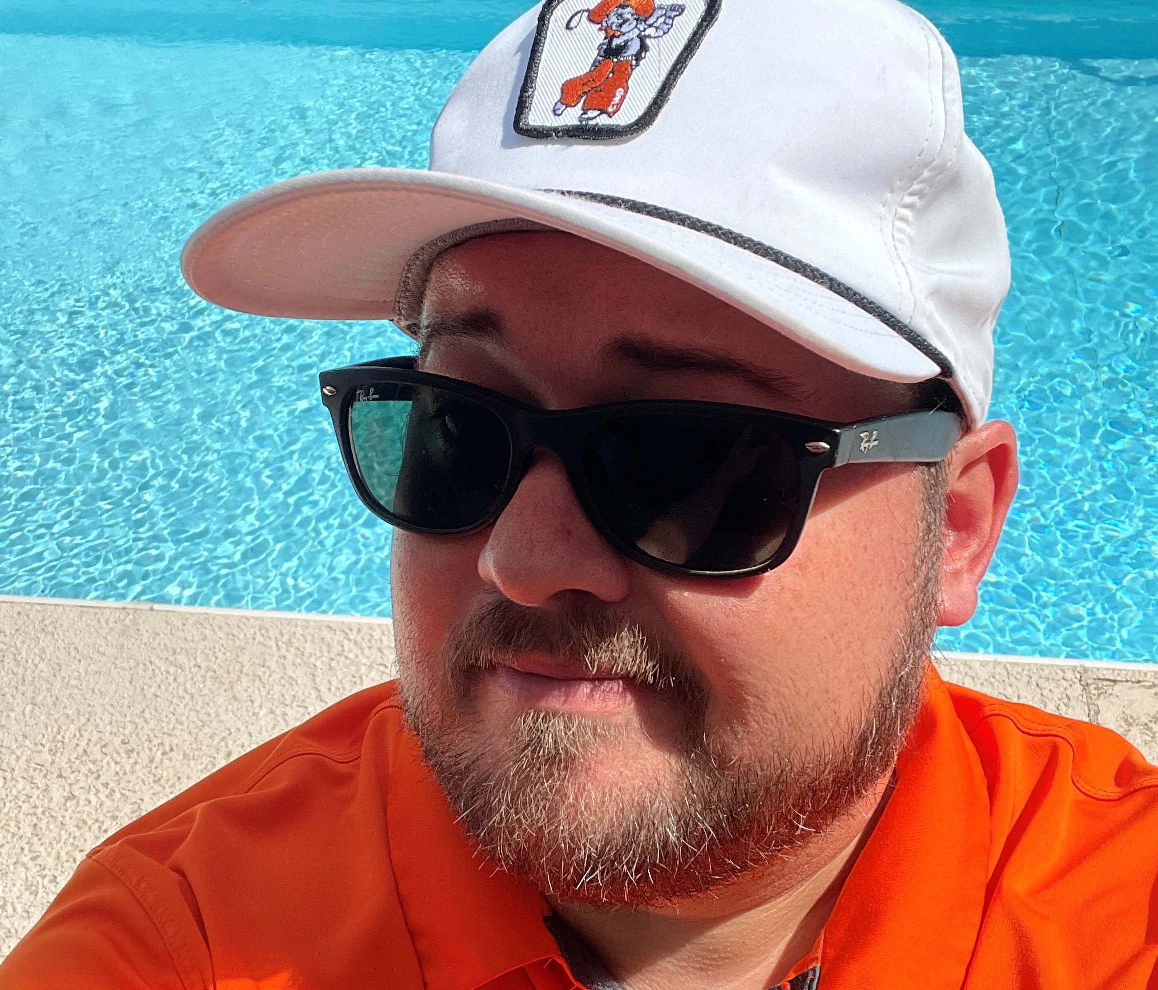 man in shades next to pool