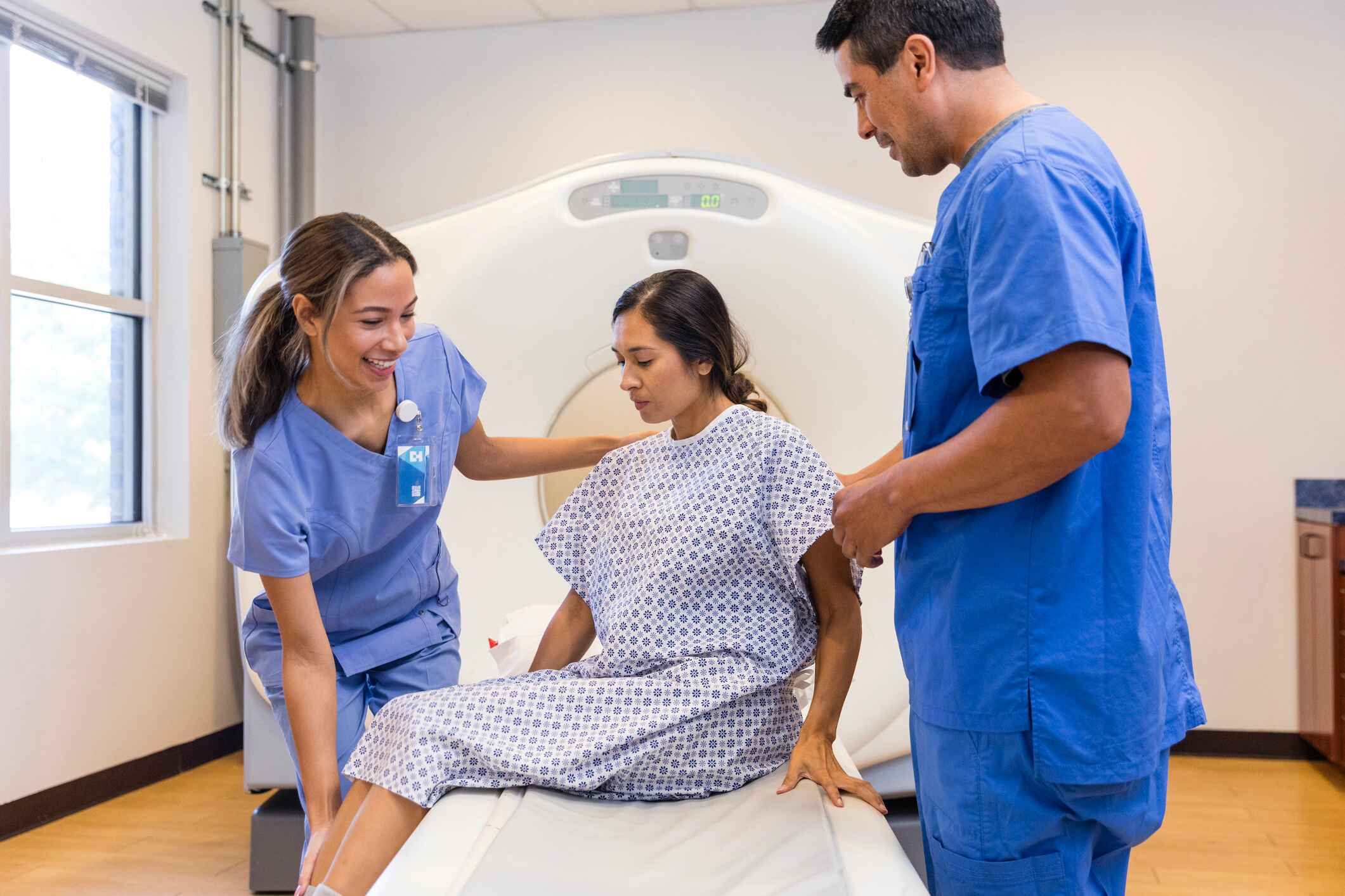 CT tech helping a patient out of the scanner