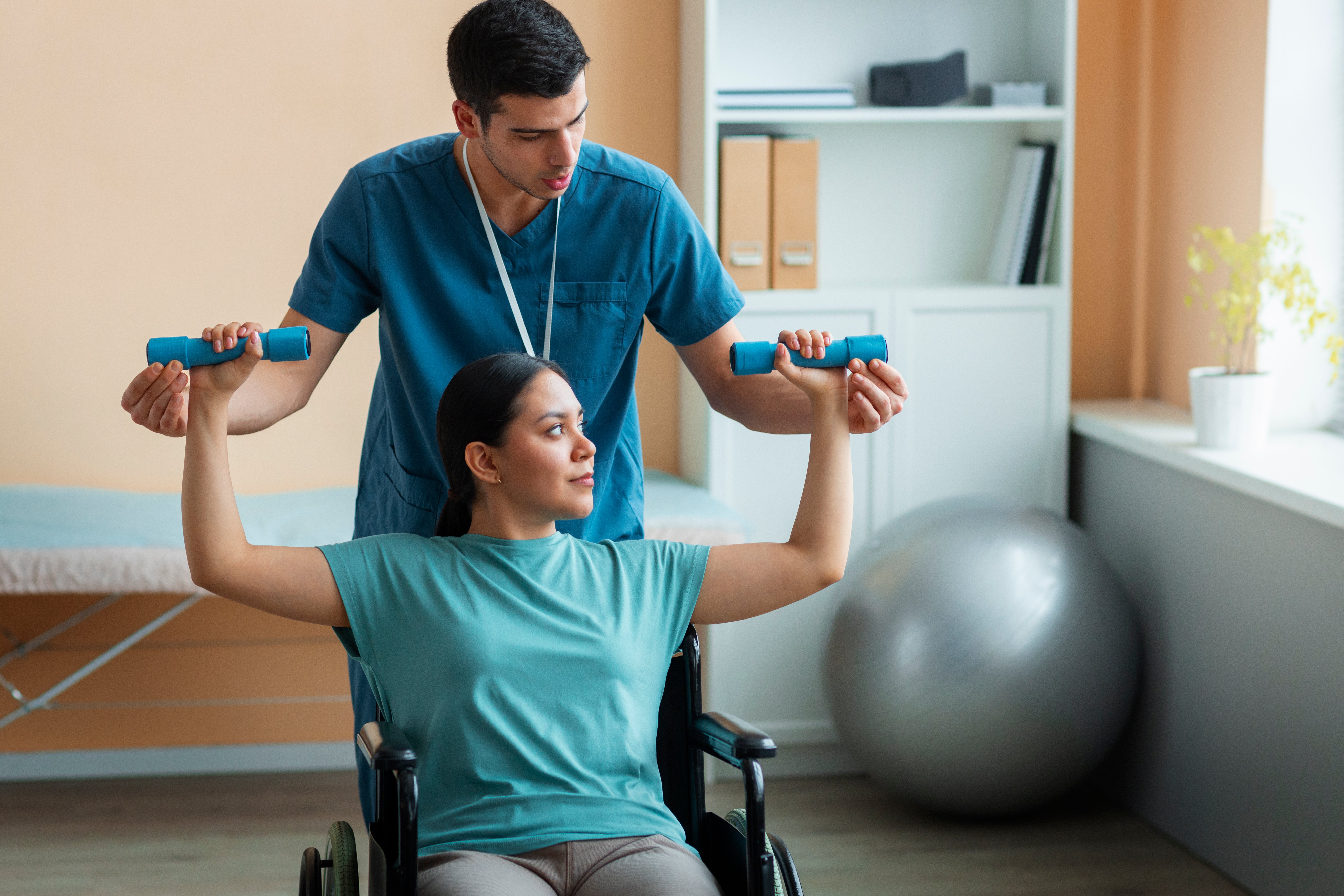 Occupational Therapist helping a patient in a wheelchair lift weights.