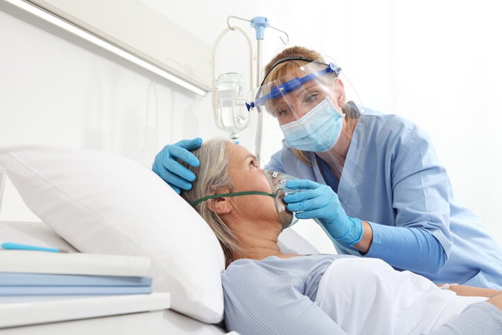 Respiratory therapist holding a mask over a patients face