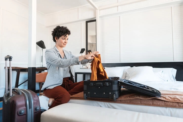 Woman folding clothes in suitcase