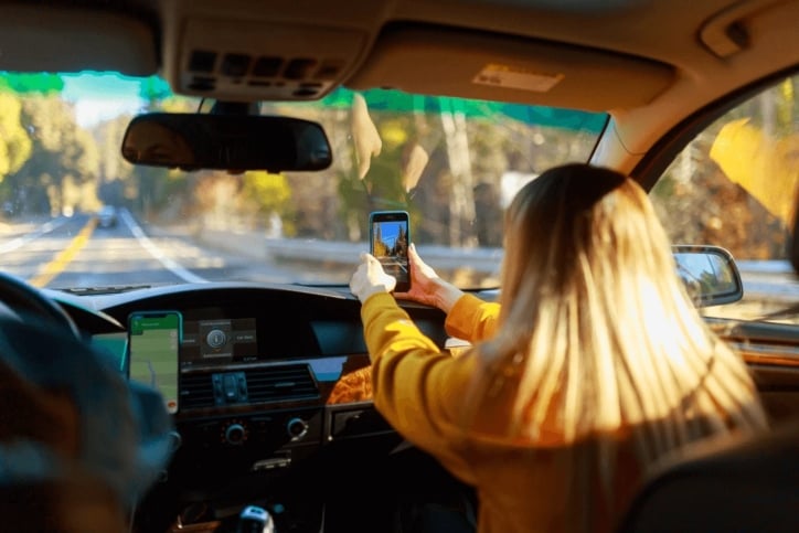 woman sitting in car with her cellphone