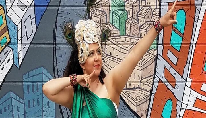 woman in green pointing at the sky