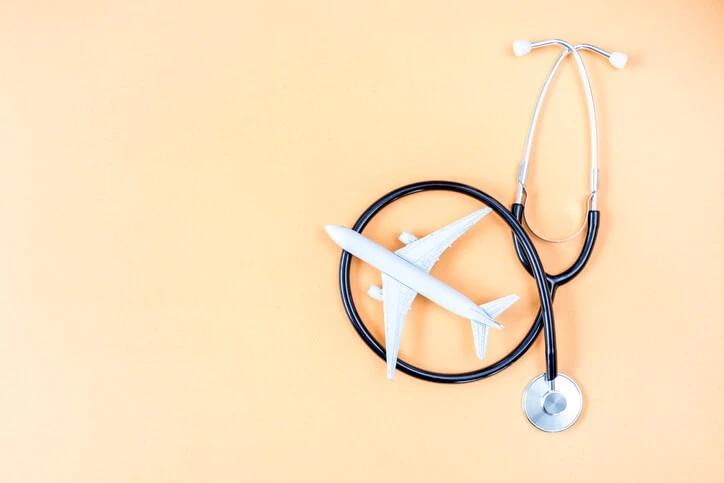 airplane model of stethoscope on peach background