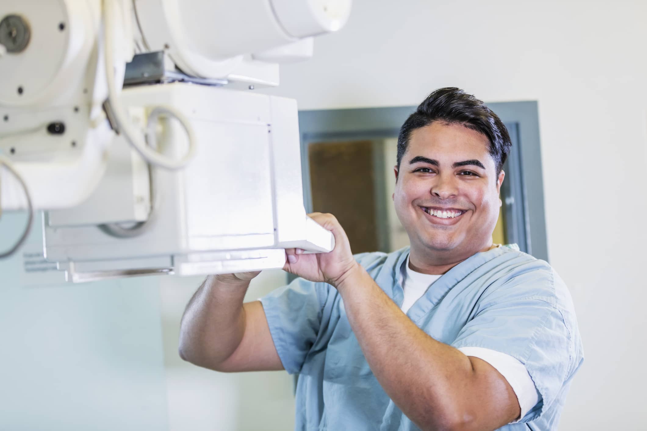 Radiology Tech Smiling while holding an x ray machine Radiology Tech Smiling while holding an x ray machine
