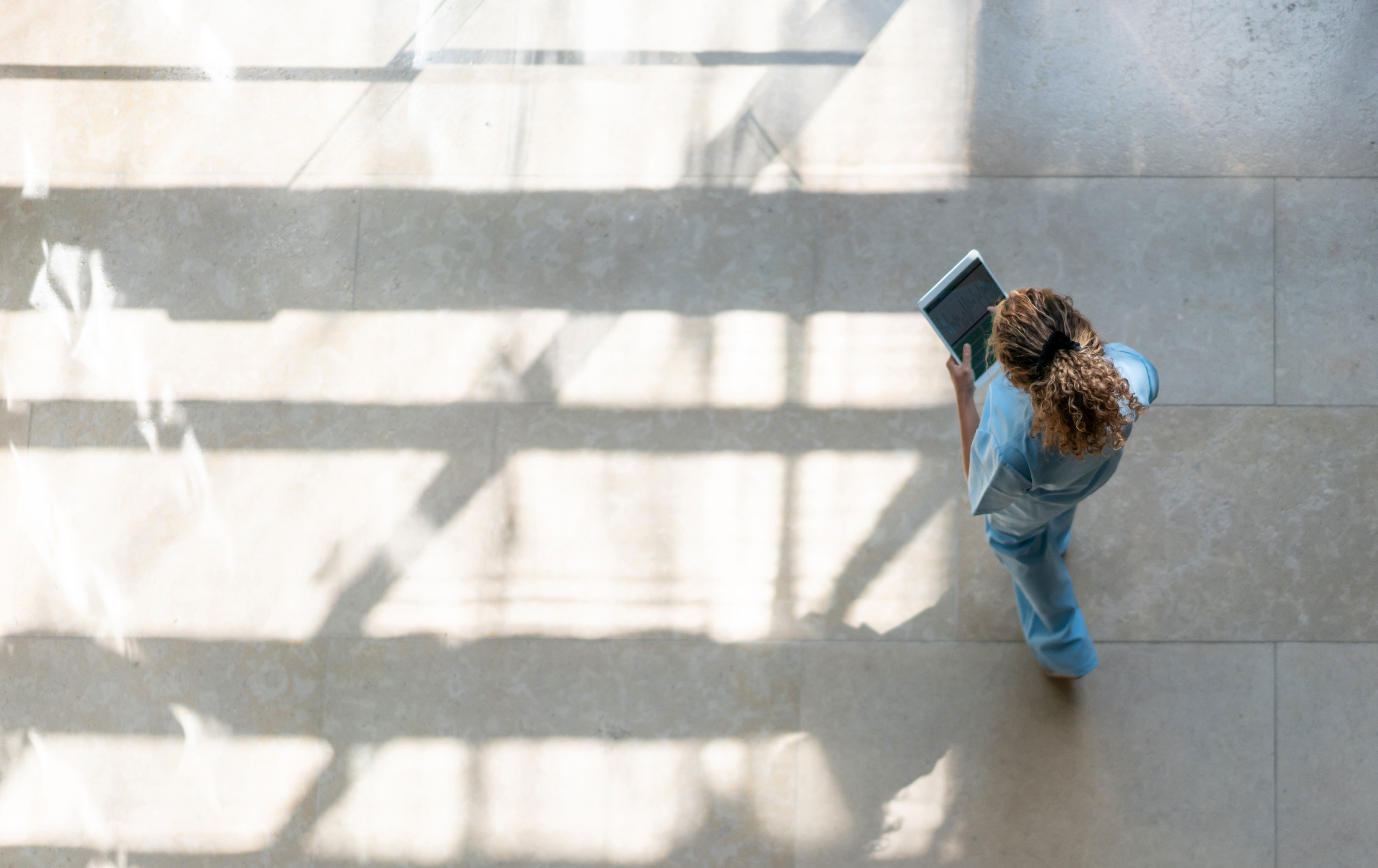 Nurse on a tablet walking outside