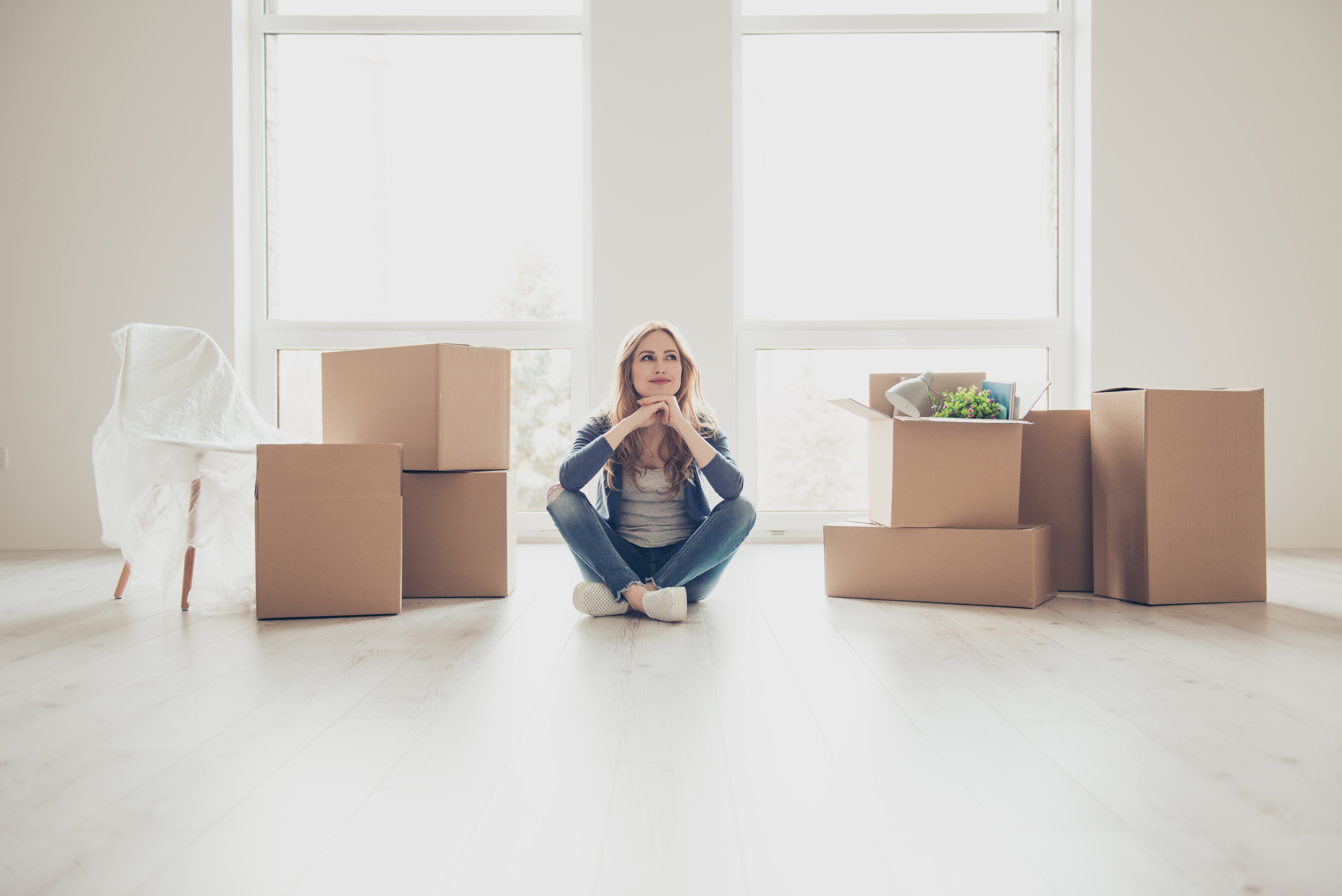 Nurse sitting in living room surrounded by moving boxes Nurse sitting in living room surrounded by moving boxes