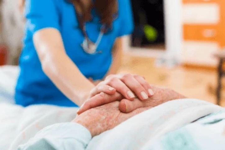 nurse with hands un top of patients hands