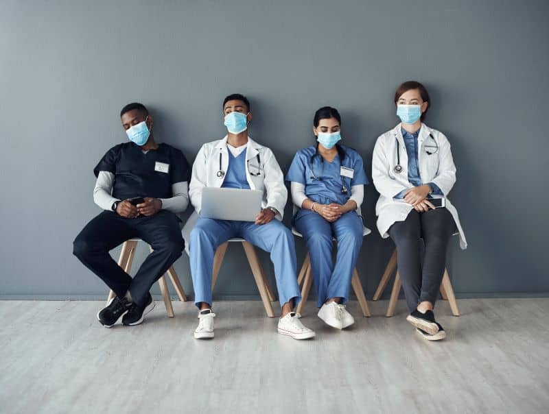 A group of overworked nurses  sitting around.