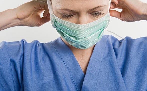 Nurse putting on mask
