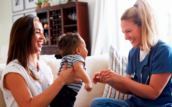 nurse with a patient and their baby at home