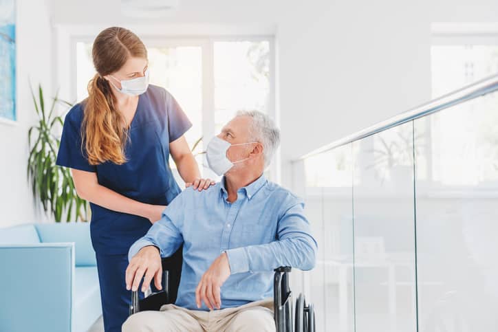 Nurse pushing patient in wheelchair in a healthcare setting