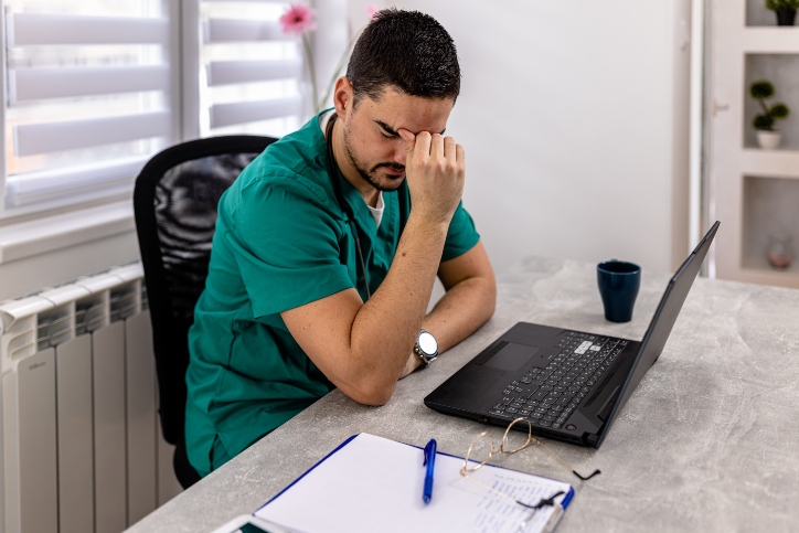 nurse sitting on chair with finger on head
