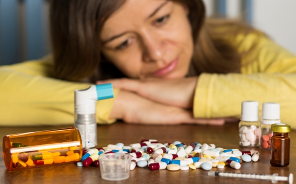 woman looking at a lot of pills