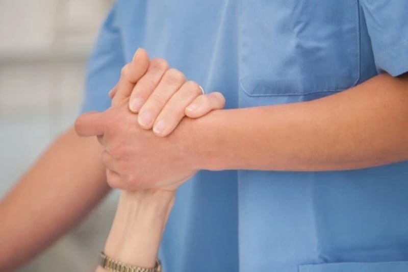 Nurse holding patient's hand