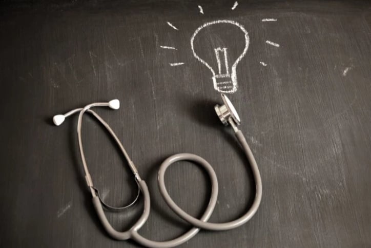 Stethoscope on chalk drawing of light bulb 