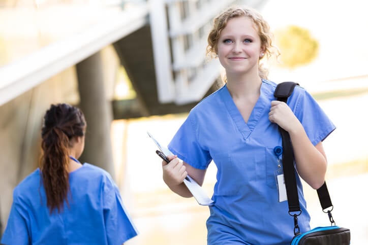 Smiling nurse walking outside at hospital
