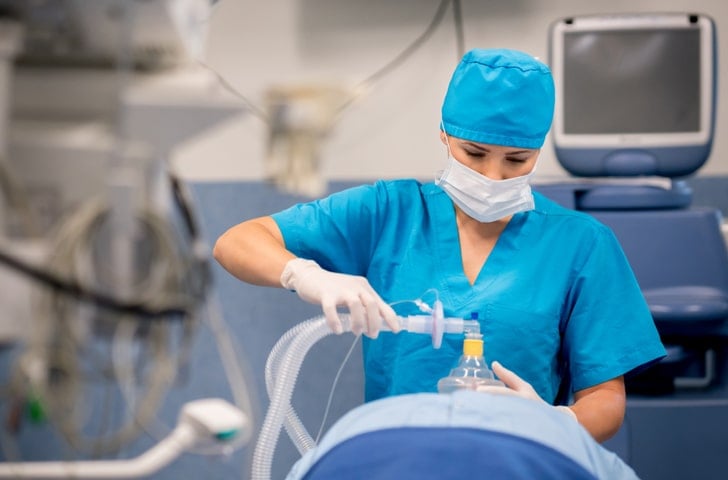 CRNA administering anesthesia in an operating room environment CRNA administering anesthesia in an operating room environment