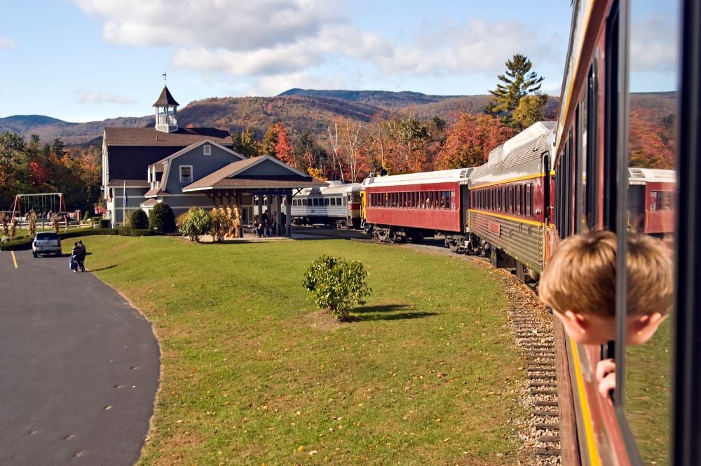 little kid riding a train and looking out of the window