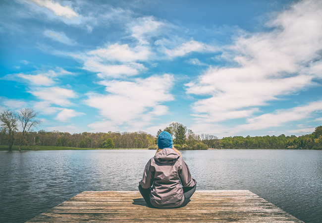 Person sitting near lake
