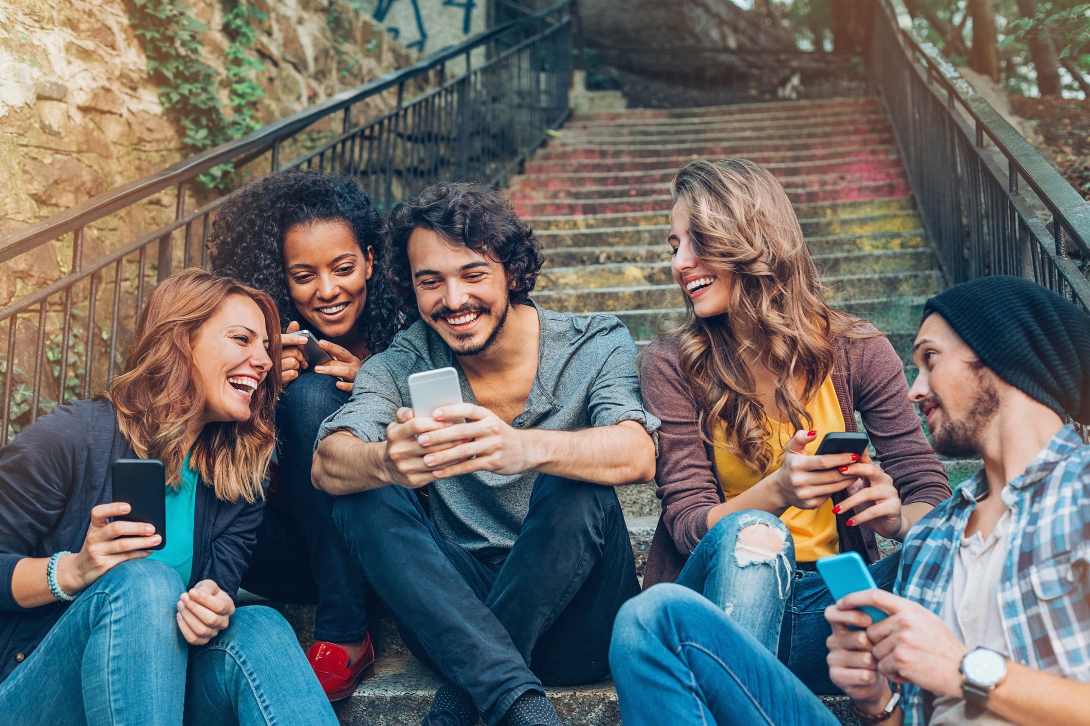 group of happy friends networking on phones