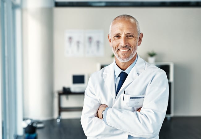 Smiling male physician in office Smiling male physician in office